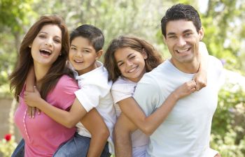 Happy familiy of four enjoying a sunny day outdoors.